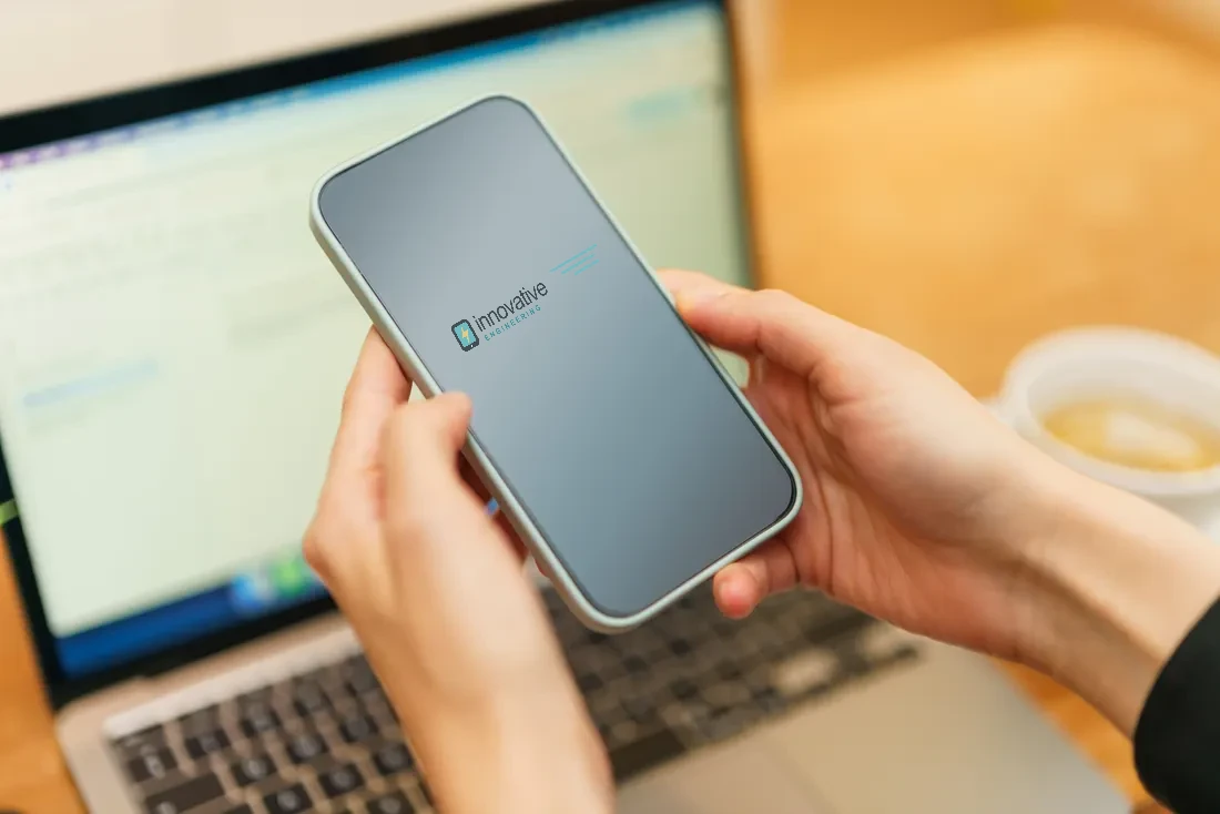 Illustrative stock composite of a phone displaying the Innovative Engineering wordmark