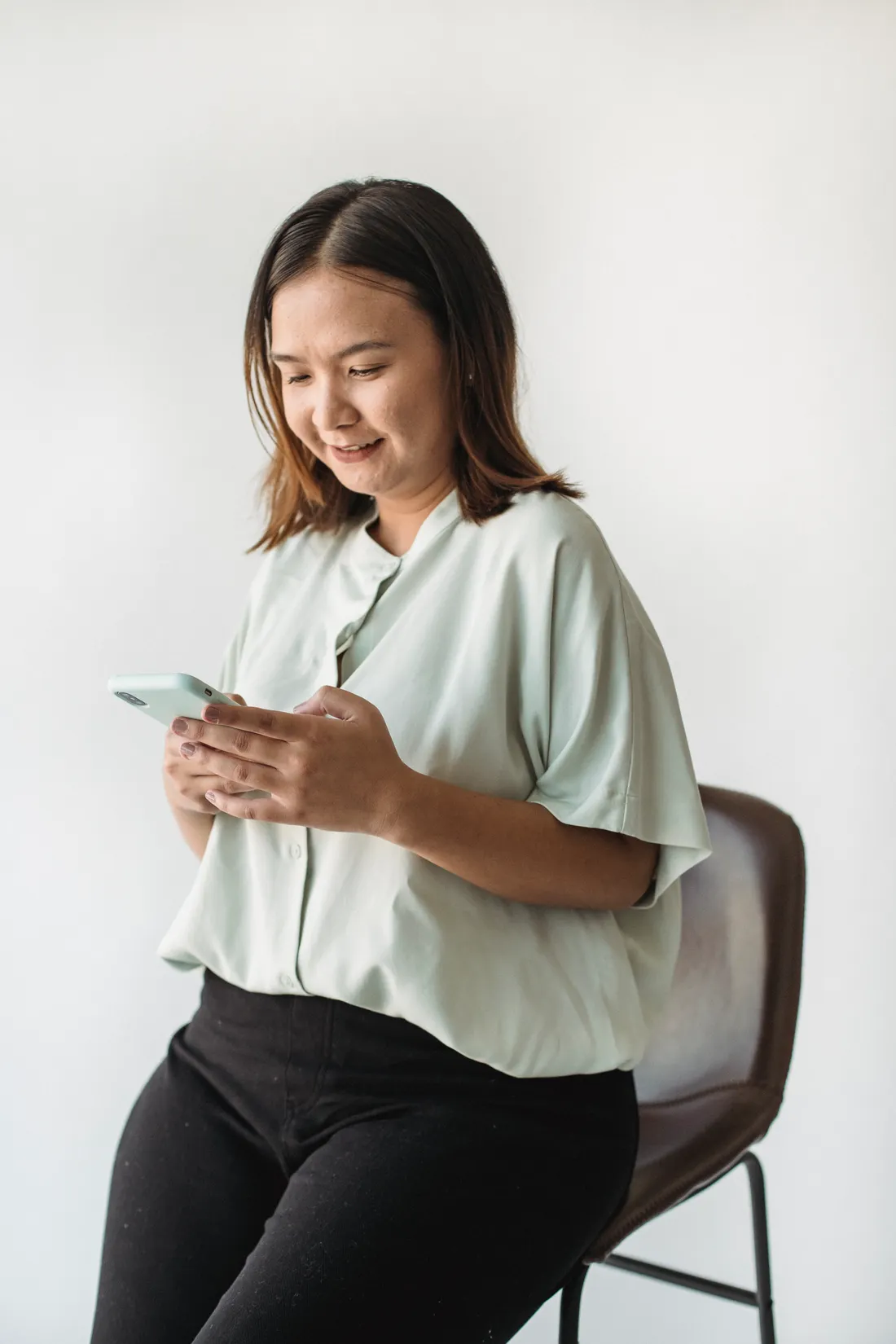 Stock photograph of a seated person reading a phone