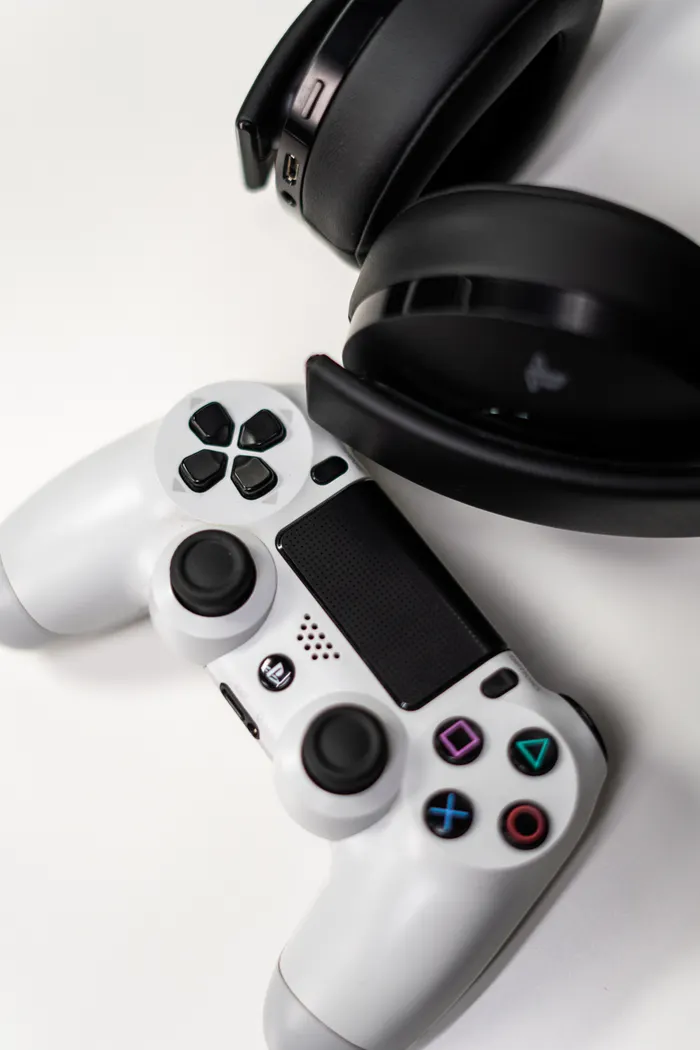 Game controller and headphones on a light surface