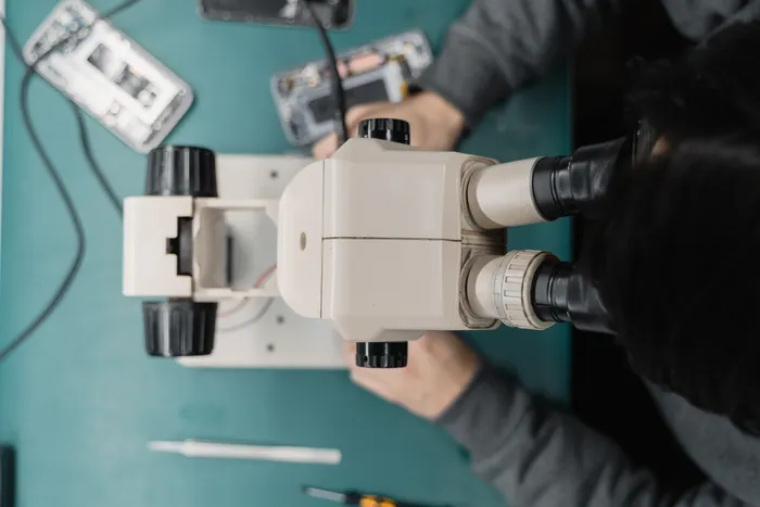 Overhead stock photograph of precision electronics work under a microscope